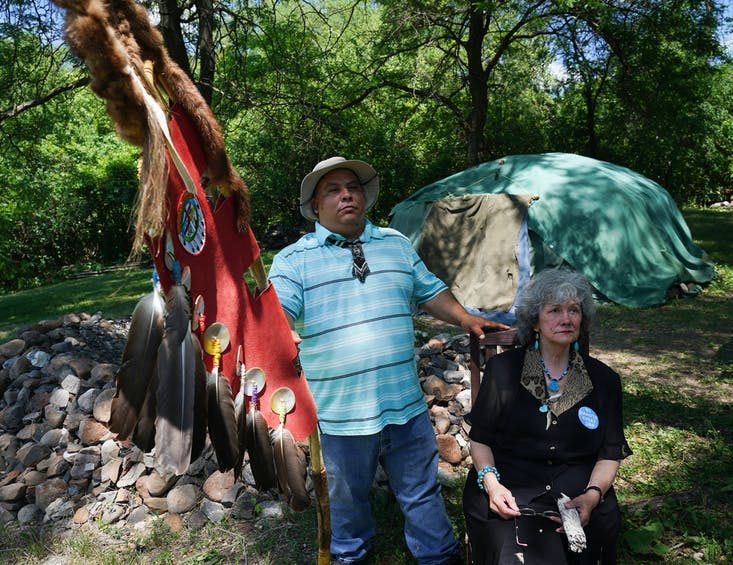 Tommy Tomahawk, tribal relations, and Mendota Mdewakanton Dakota Tribal Community chairperson Sharon Lennartson sat in the shade in front of a sweat lodge for a portrait.